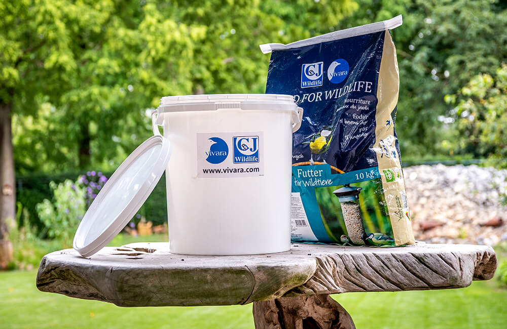 Opbevaringsspand ved siden af en stor pose med frø.